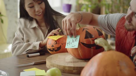 friends stick name stickers on halloween pumpkins