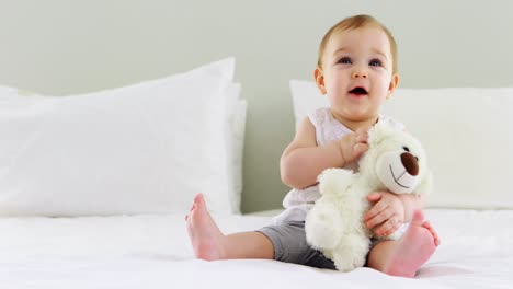 Linda-Niña-Jugando-Con-Un-Peluche-En-La-Cama