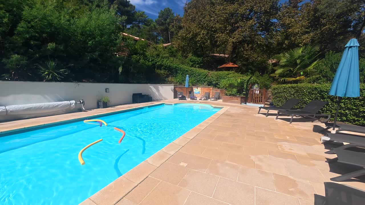 Mand stiger op af blåt swimmingpoolvand på en solskinsdag
