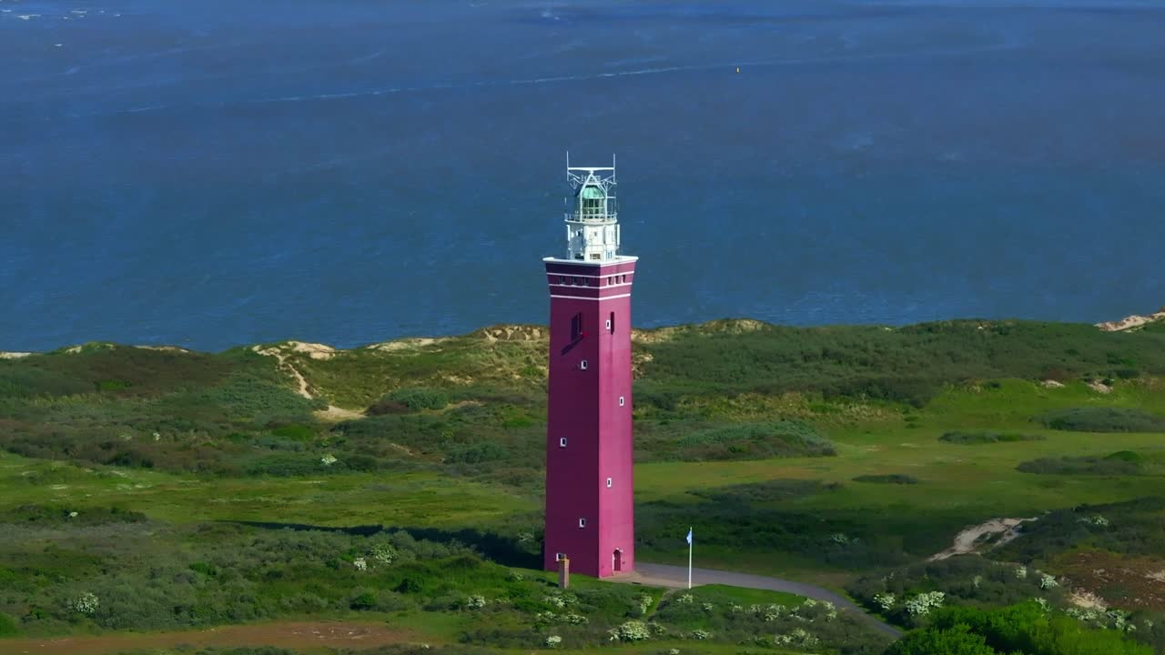 Vista aerea dell'iconico faro di Westhoofd sulla spiaggia di Ouddorp con dune estese e la vasta costa del Mare del Nord dei Paesi Bassi
