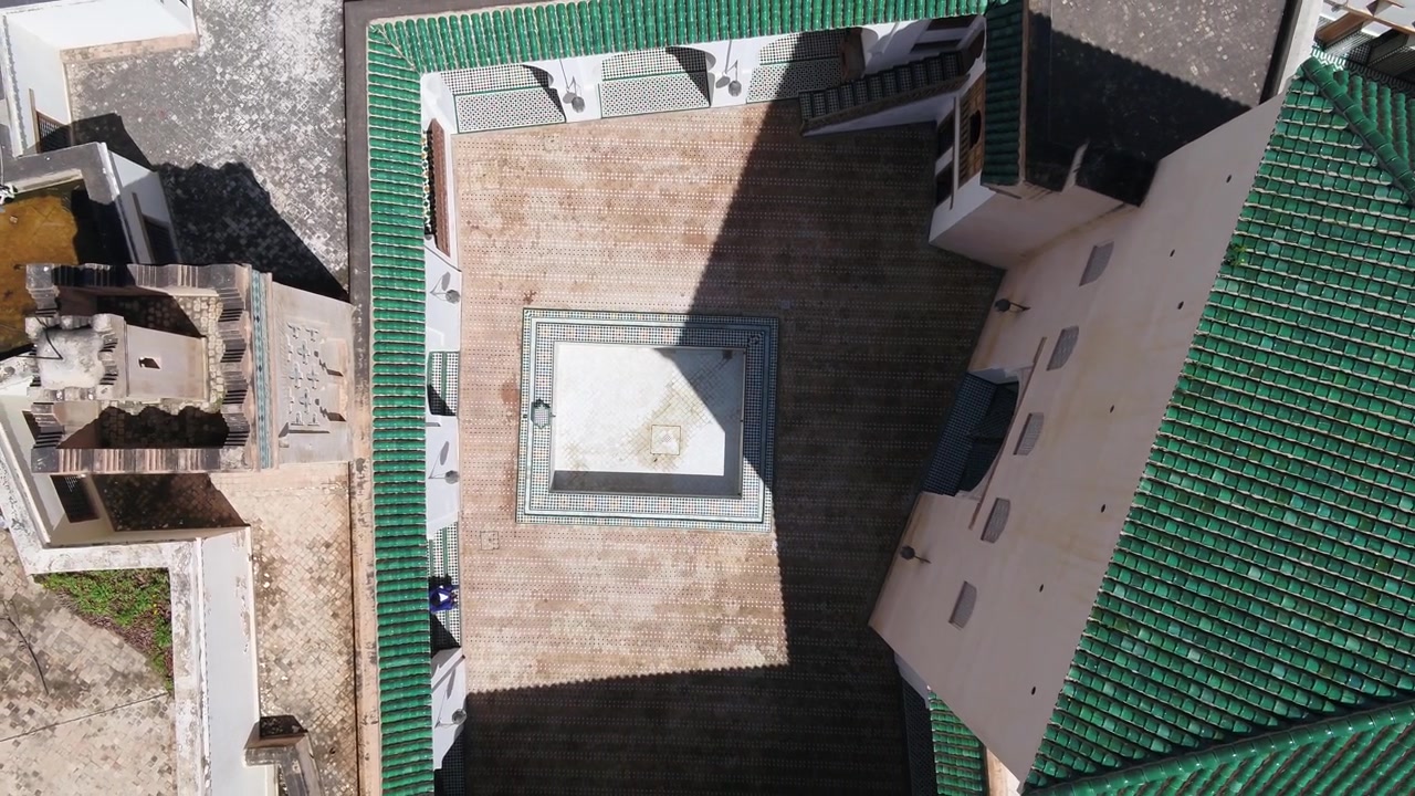Vista aerea dall'alto con drone di un tradizionale cortile marocchino con disposizione geometrica e tetti con tegole verdi a Fez, Marocco, ideale per progetti culturali