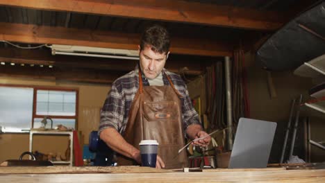 focused caucasian male knife maker in workshop preparing knife mold