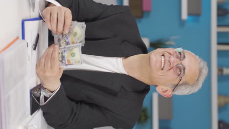 재 ⁇ 고 재 ⁇ 는 돈을 세는 홈 오피스 직원 남자의 수직 비디오.