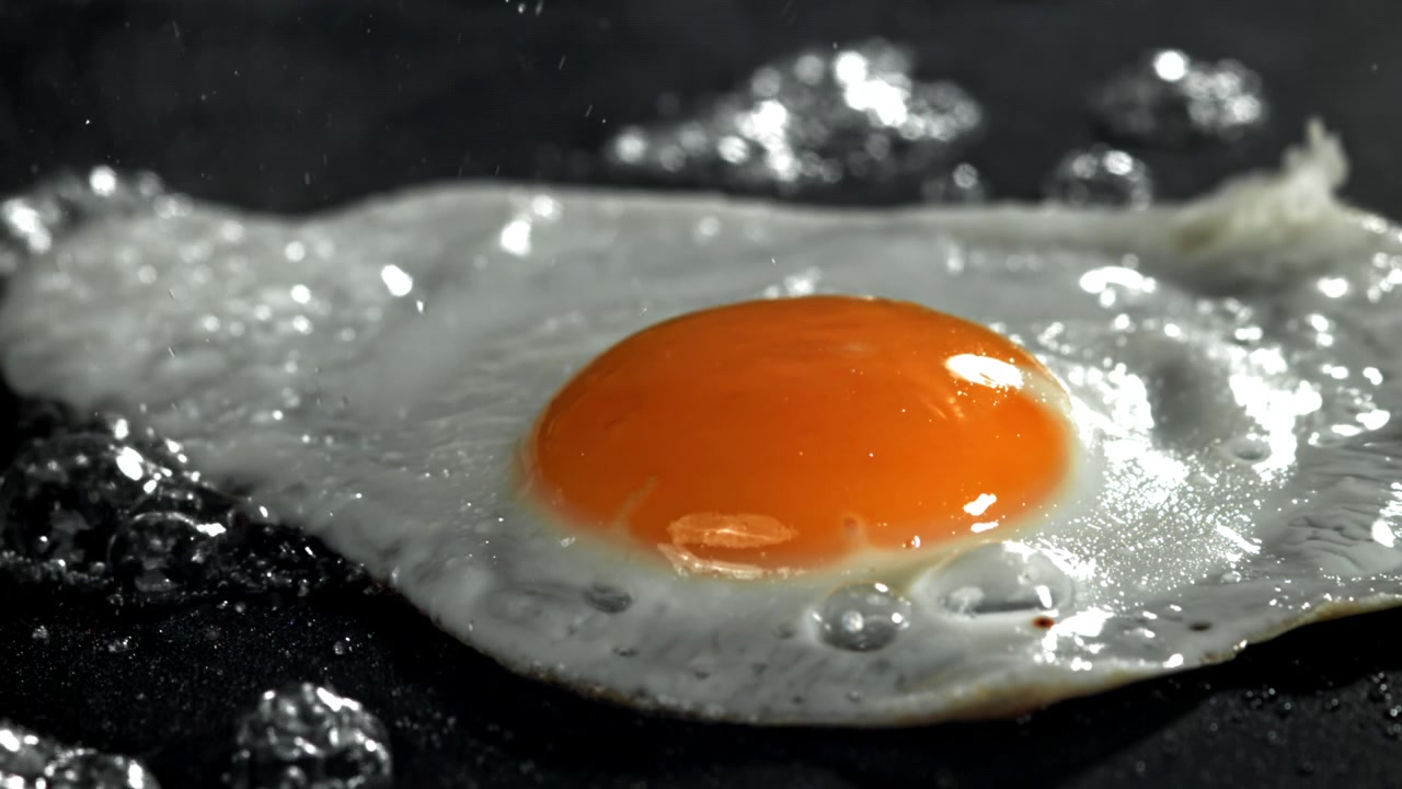 Close-up of a Fried Egg Sizzling in a Hot Pan