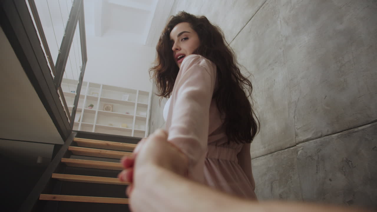 una pareja joven subiendo las escaleras en lencería.