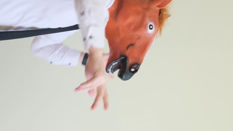 crazy young man in a horse mask dancing rhythmically on a white background crazy young man in a horse mask dancing rhythmically on a white background slow motion the holiday of happiness horse face positive emotions