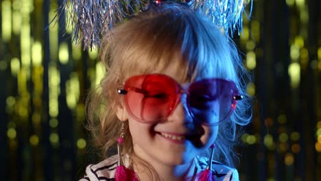 Portrait-of-trendy-stylish-girl-looking-at-camera,-smiling,-child-kid-in-neon-light-at-disco-club