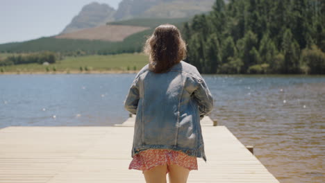 Mujer-Aventurera-Corriendo-En-El-Embarcadero-Desnudándose-Lista-Para-Saltar-Al-Lago-Disfrutando-De-La-Libertad-Del-Verano