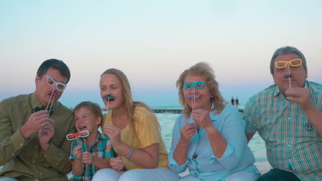 family playing with flase glasses and moustache