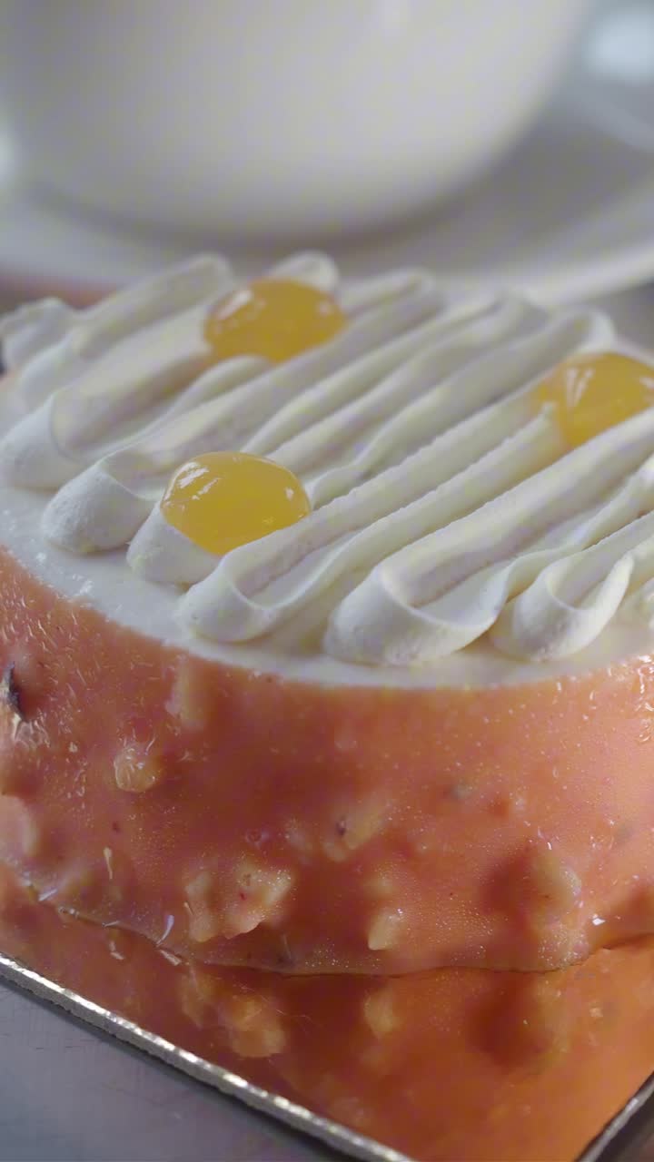 Close-Up of a Small Pink Cake with White Frosting and Yellow Topping