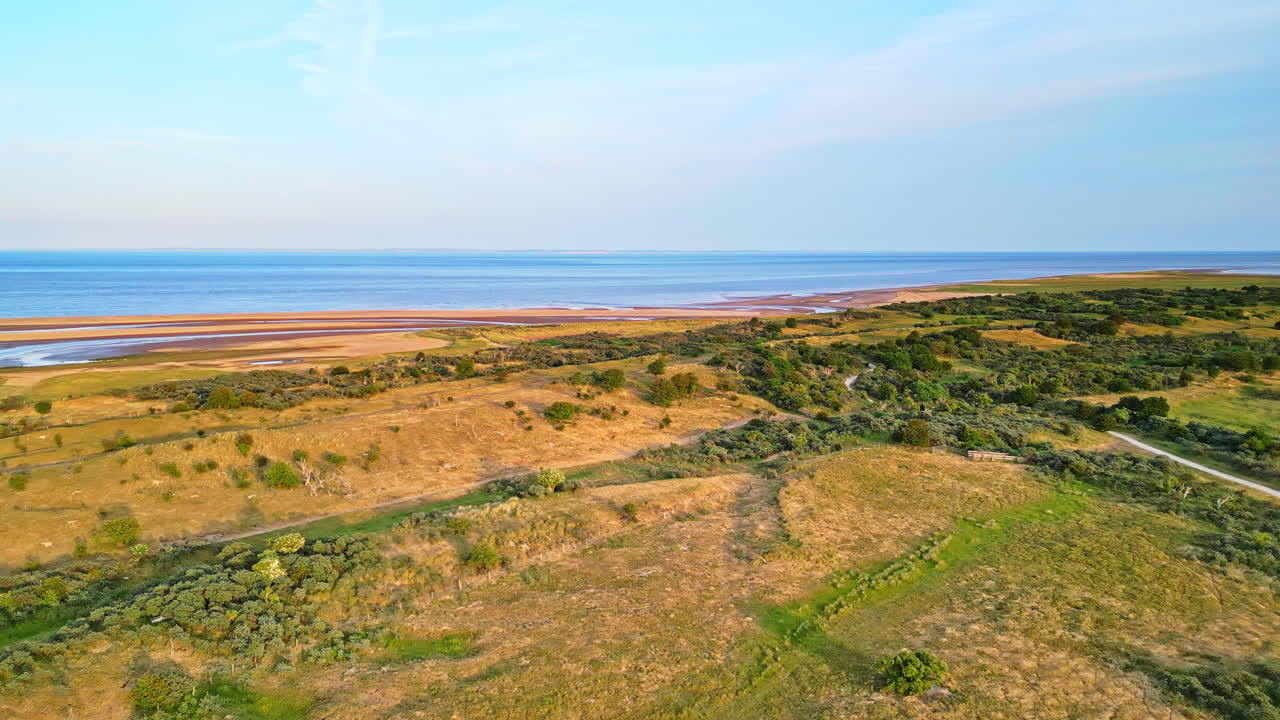 descubra el encanto idílico de una escena costera de la hora de oro a través de impresionantes imágenes aéreas de drones: estuario, bancos de arena, océano y pantanos