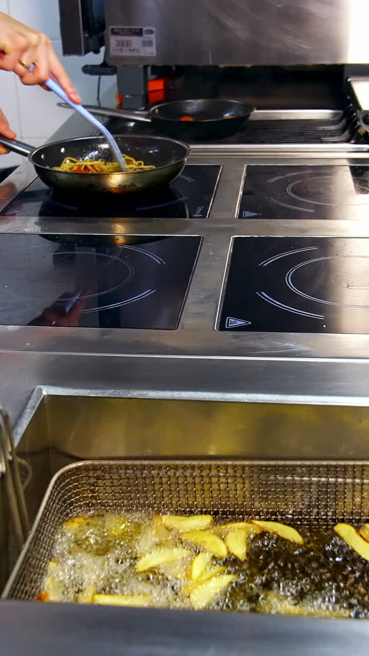 Deep fryer in the kitchen restaurant. Chef is cooking food in the ...