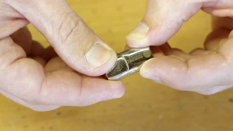 Hands-of-craftsman-checking-silver-bracelet-clasp-in-close-up-view