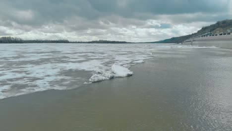 Río-Ancho-Con-Hielo-Blanco-Rodeado-De-Densos-Bosques-Montañosos