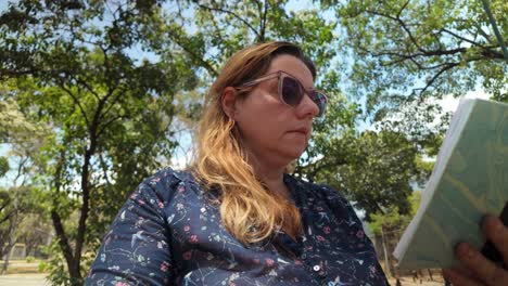 woman connecting with nature spending time outdoors. sense of peaceful reading and relaxation. nature background out of focus