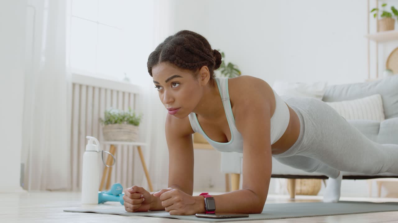 mujer haciendo un ejercicio de tabla en casa