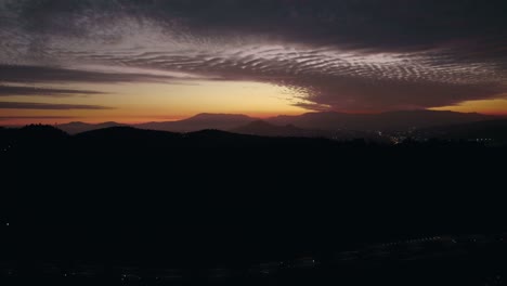 vista aérea de una tranquila puesta de sol entre colinas islas santiago chile, fondo con nubes y débil luz solar