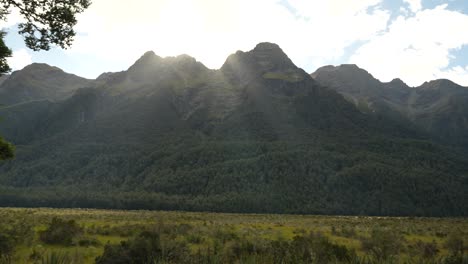 el sol nace detrás de las montañas brillando en los lagos espejo del parque nacional de fiordland