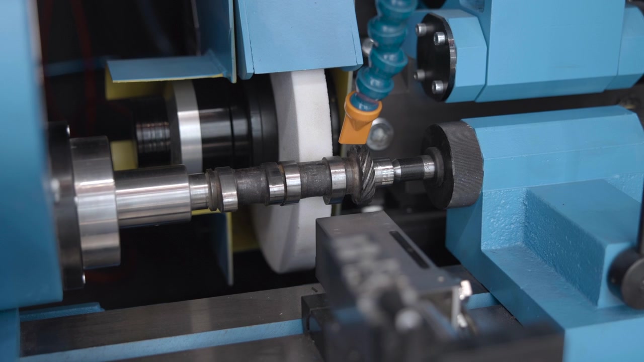 Denne videoen viser driftssekvensen til industrimaskineri i et fabrikkmiljø, filmet i nærbilde. Fokuset er på de intrikate metall- og plastdelene.