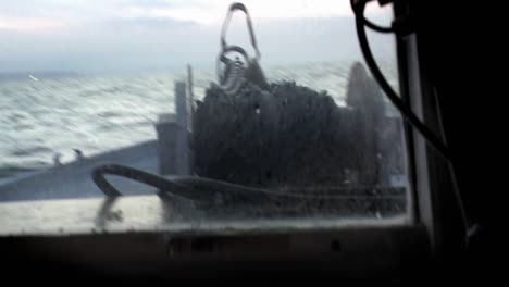 a rope is released into the water from the deck of a boat as the captain sits at the controls