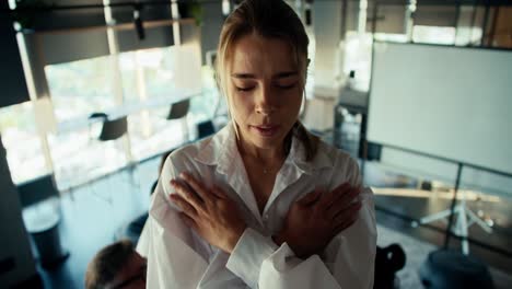 A-young-blonde-girl-in-a-white-shirt-is-worried-before-making-a-blind-fall-into-the-hands-of-her-colleagues-in-the-office.-mutual-trust-therapy