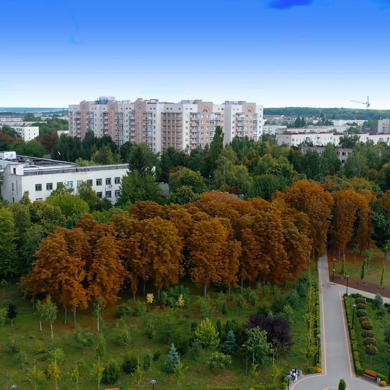 City park with beautiful architecture. Drone flying over the garden and then flying to residential area