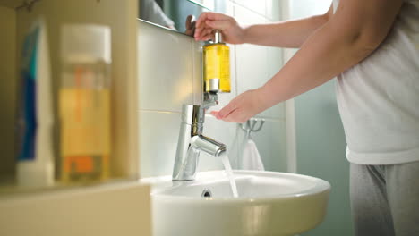 woman washing hands with liquid soap