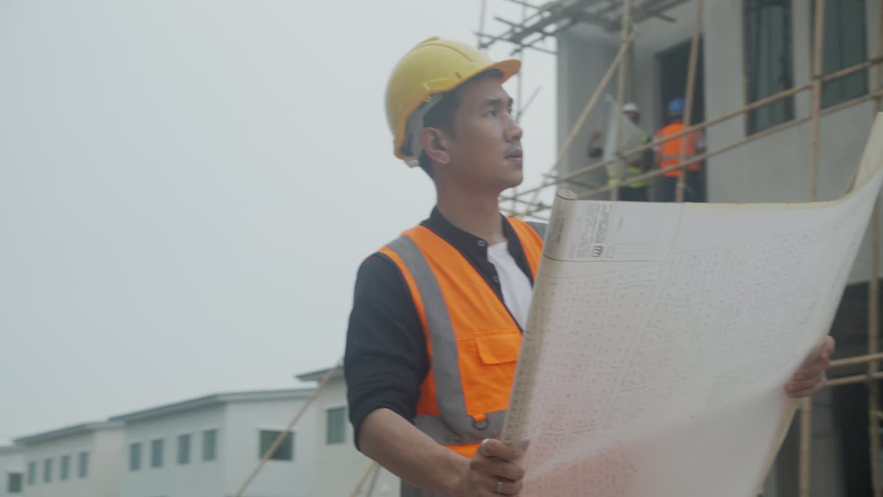 arquitecto o ingeniero hombre que usa un sombrero duro que busca un plan para inspeccionar y planificar la construcción en el sitio de construcción, contratista o constructor examinando el proyecto con un profesional para el éxito.