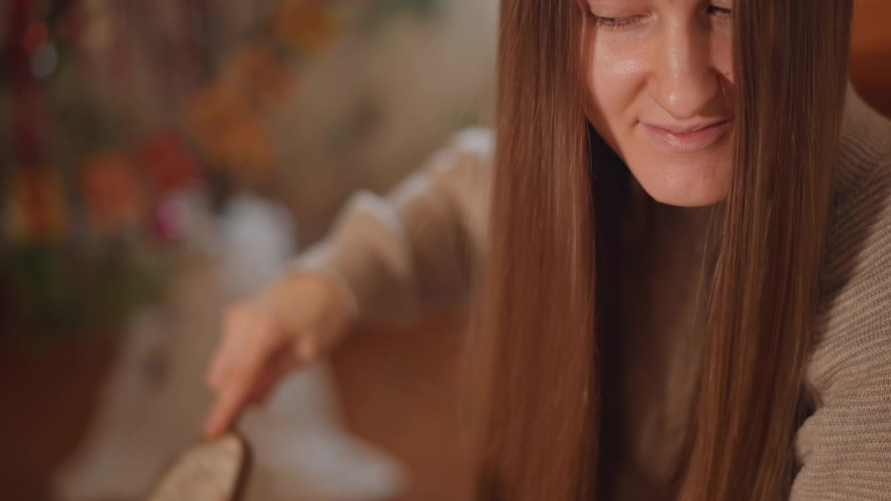 Rutina de cuidado suave. Primer plano de mujer arreglándose el cabello. Ambiente íntimo con una mujer cuidando su cabello delicadamente. Toma detallada en interiores de una mujer cuidando su cabello con suavidad y atención.