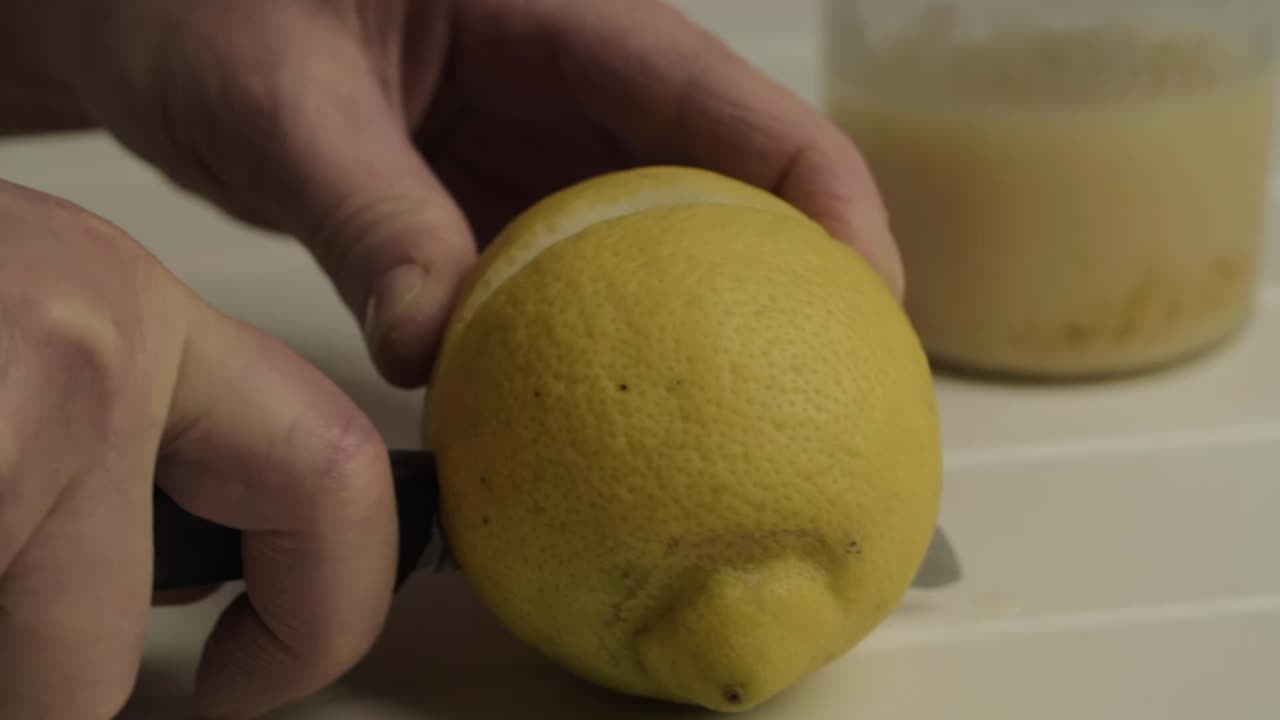 Hand slicing juicy lemon close up shot
