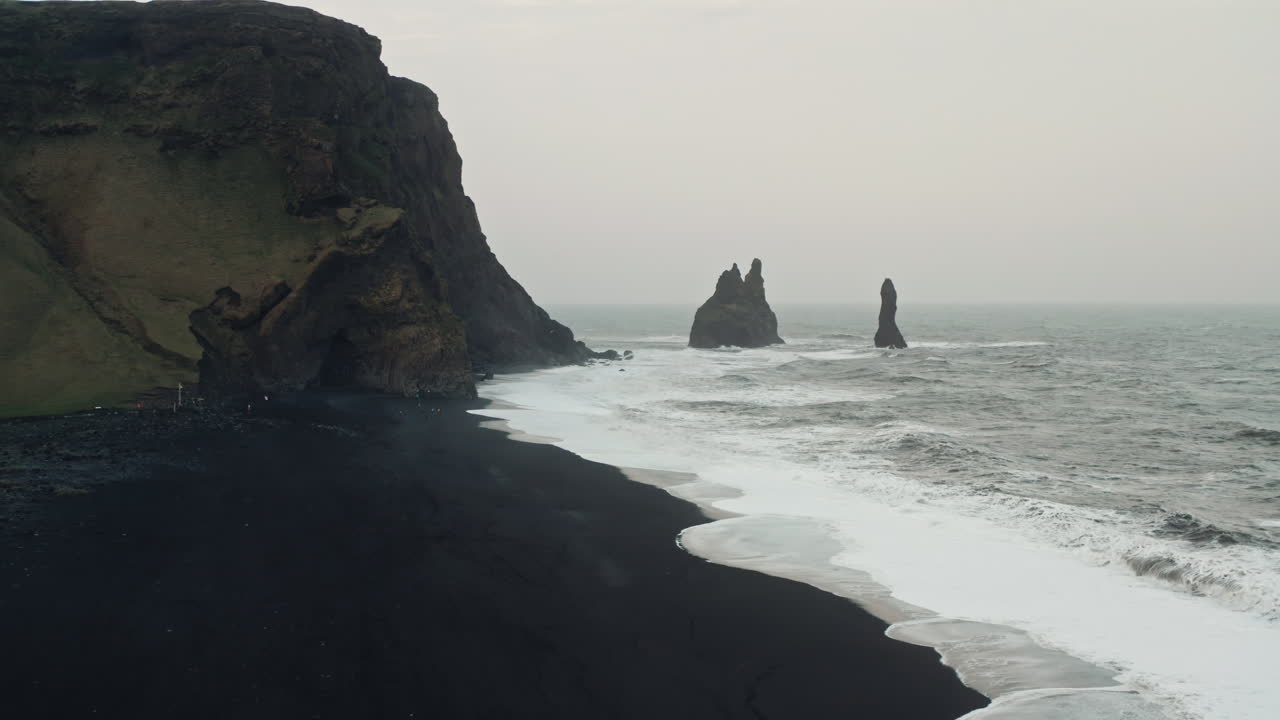 tomada aérea cinematográfica de la playa de arena negra de reynisfjara, vik - islandia