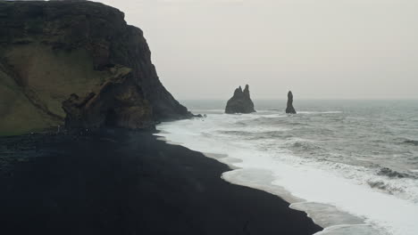 cinematic aerial drone shot of black sand beach of reynisfjara, vik - iceland