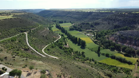 aerial view of a valley with winding roads and farmlands