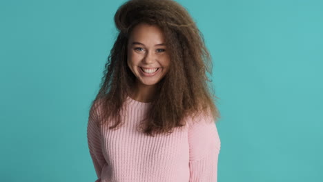 caucasian curly haired woman with thumbs up in front of the camera.