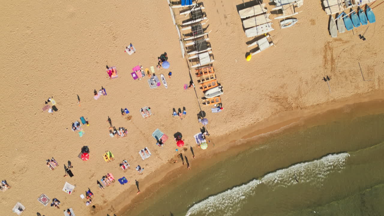 Drone top-down shot capturing beach filled with swimmers and sunbathing families, creating unforgettable memories during the summer holidays