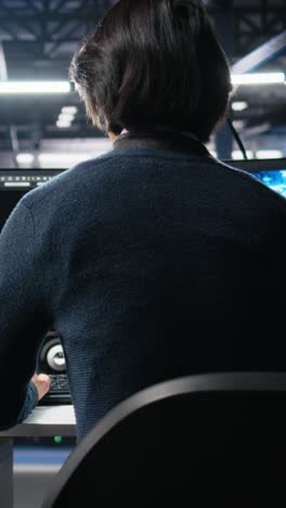 vertical video admin entering data center office, reviews ai diagnostics on computer