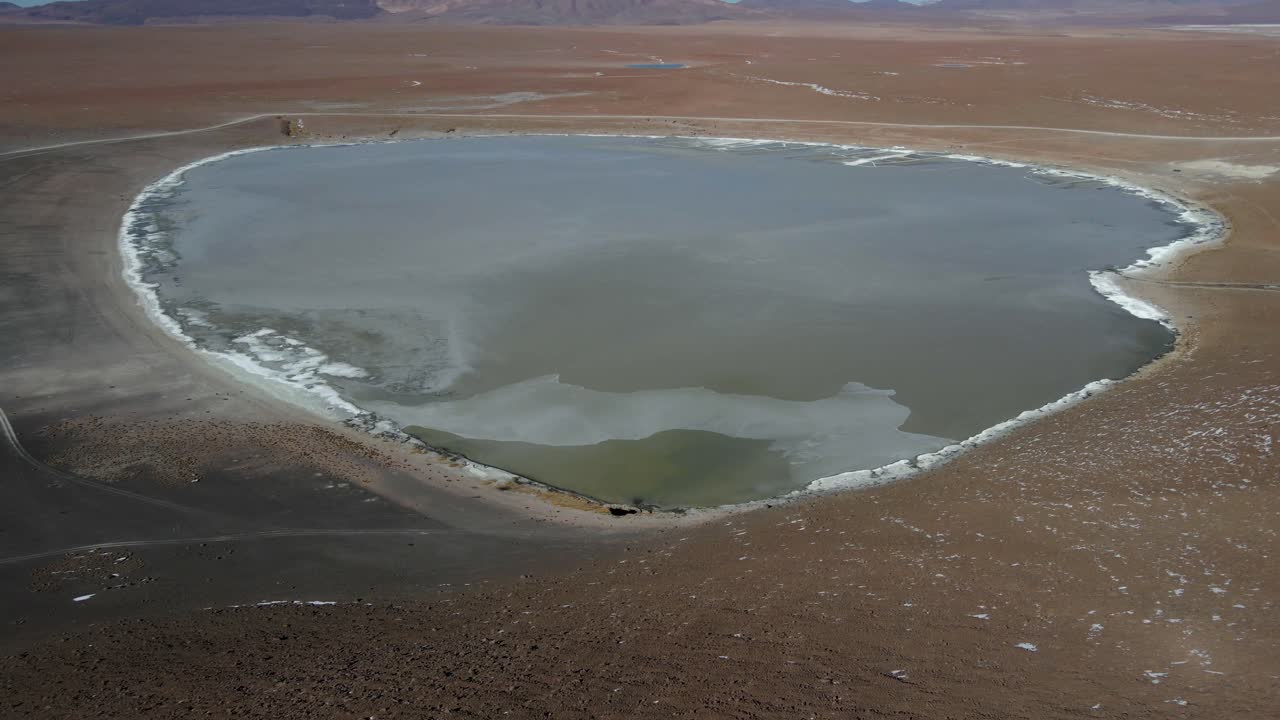 Drone captures turquoise waters and mineral shoreline of Kollpa Lagoon in Bolivia