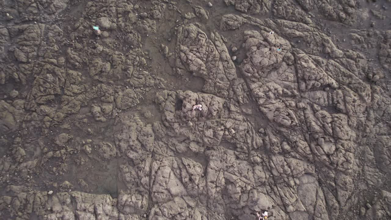 top down drone levantando una foto de una pareja de pie en la playa de tamarindo en costa rica
