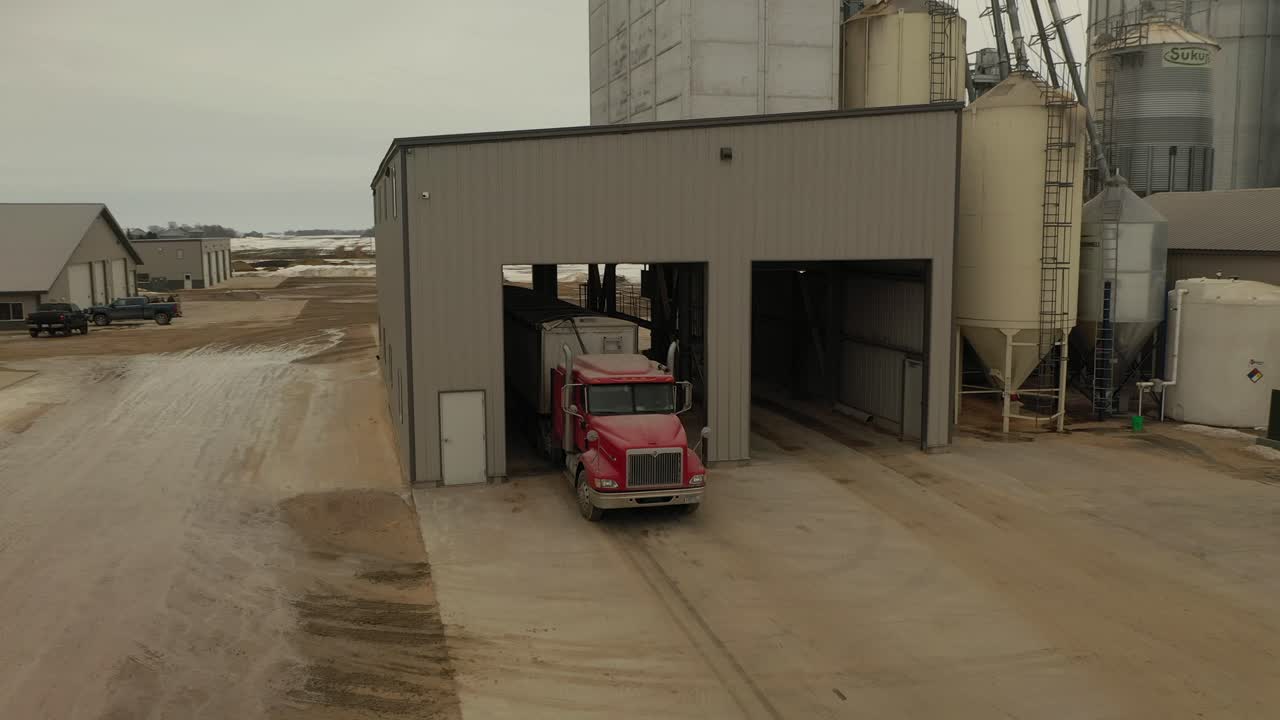 Drone shot of a semi loading feed at a farm's feed mill in Minnesota
