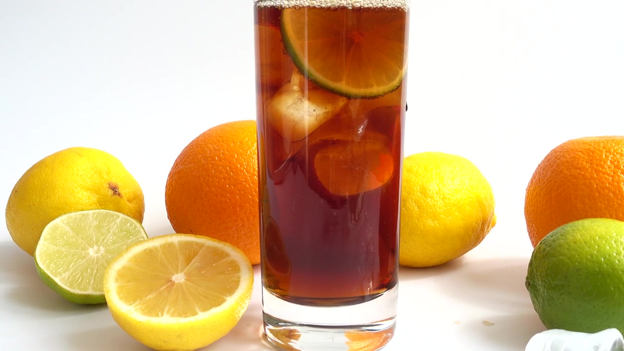 Preparazione di una bevanda in bicchiere con ghiaccio e lime.