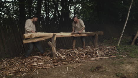 two men working on a log
