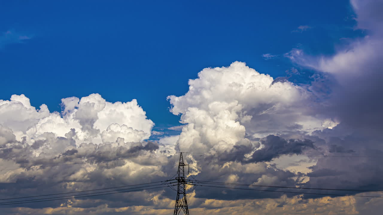 High Voltage Electrical Transmission Tower With Moving Dense Clouds Background