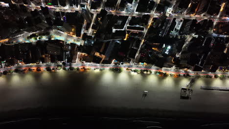 drone footage gliding over camboriú’s illuminated high-rises and shoreline, capturing the contrast between urban glow and night time serenity. ideal for city tourism campaigns