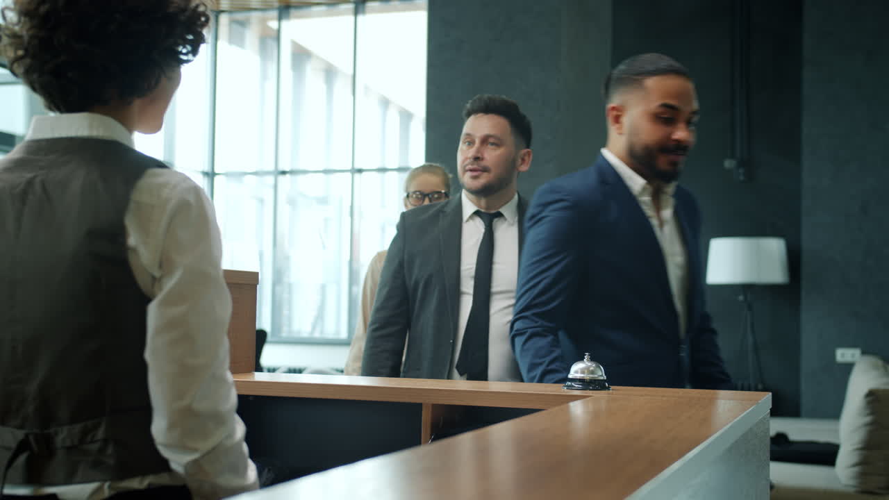Business People Checking In at Hotel Reception