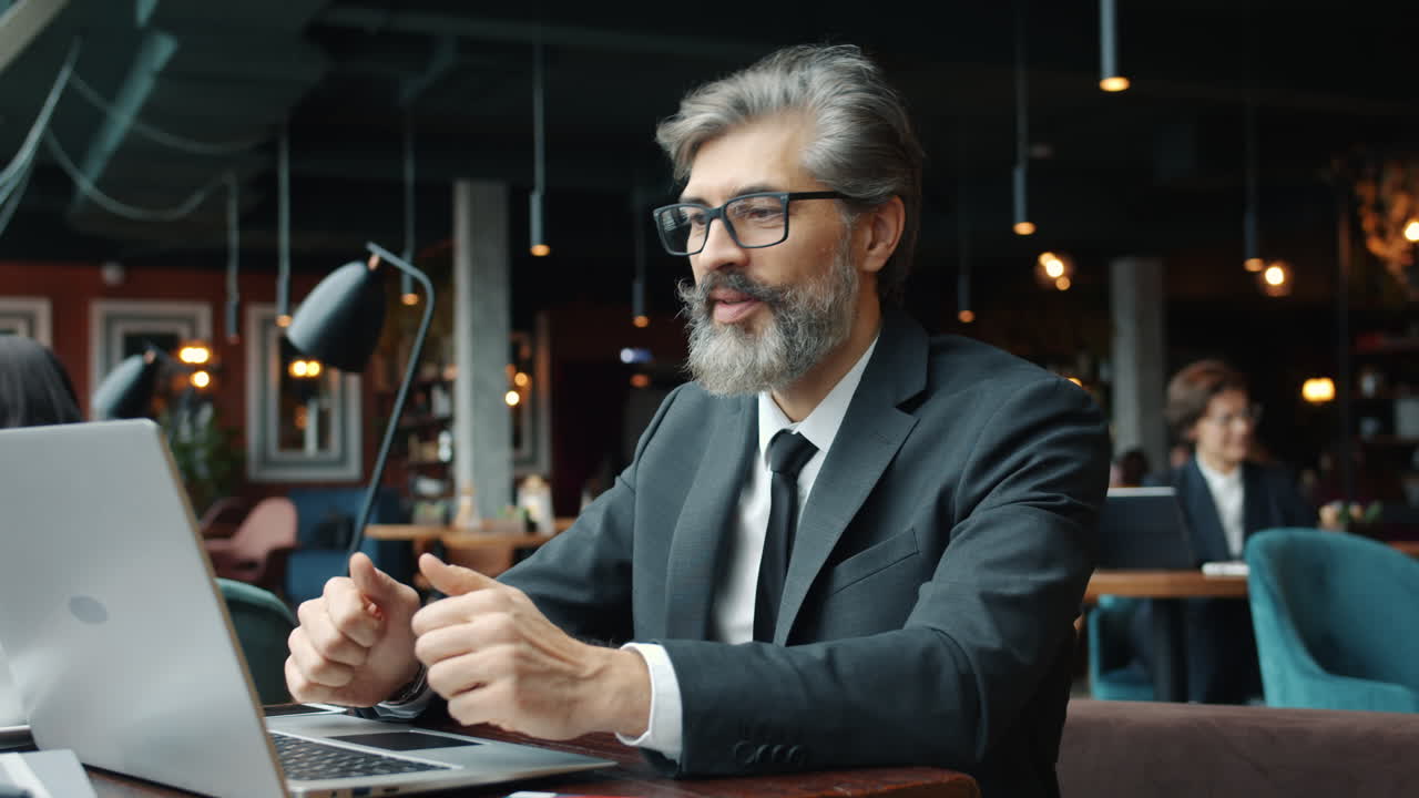 Forretningsmand, der arbejder på bærbar computer på café