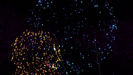 animation of buon anno text in pink with colourful new year fireworks exploding in night sky
