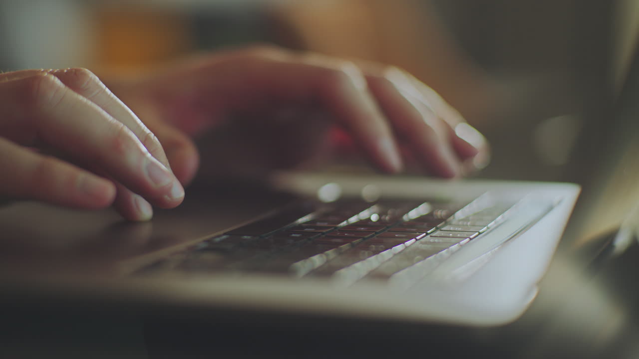 Close-up of Hands Typing on a Laptop Keyboard