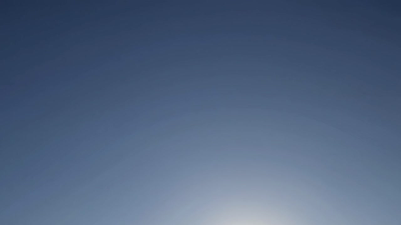 A serene sky with a gradient from light to deep blue, captured from a low angle