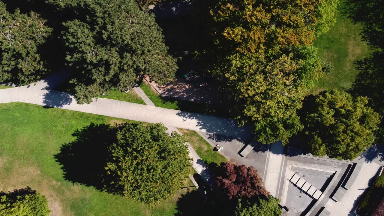 2-4 moderno parque circular futurista con forma de pájaro vista aérea subida sobre la piscina vacía de la fuente de agua seca a través del parque infantil restringido durante la pandemia de covid-19 distanciamiento social caminos del centro de autobuses de la ciudad