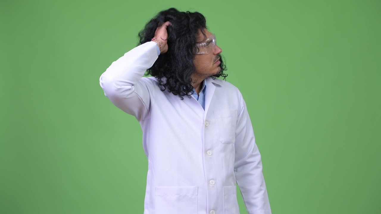 Crazy scientist wearing protective glasses scratching head